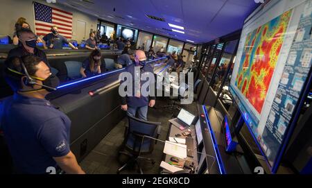 Pasadena, Kalifornien, USA. Februar 2021, 18th. Mitglieder des NASA-Teams Perseverance Mars Rover beobachten in der Missionskontrolle, wie die ersten Bilder eintreffen, kurz nachdem die Sonde erfolgreich am Donnerstag, den 18. Februar 2021, auf dem Mars im Jet Propulsion Laboratory der NASA in Pasadena, Kalifornien, landete. Ein wesentliches Ziel der Mission von Perseverance auf dem Mars ist die Astrobiologie, einschließlich der Suche nach Zeichen des antiken mikrobiellen Lebens. Quelle: dpa picture Alliance/Alamy Live News Stockfoto