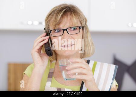 Ältere Frau trägt eine Brille und telefoniert Stockfoto