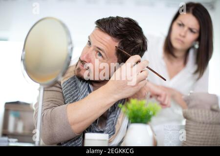 Junger Mann, der Haare mit Kamm putzt Stockfoto