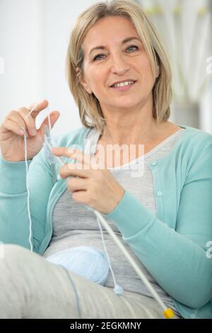 Nachdenkliche glückliche Frau sitzt und entspannt sich auf der Couch zu Hause Stockfoto