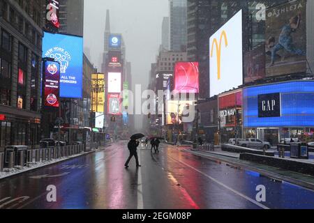 18. Februar 2021 : EIN leichter Schneesturm traf New York City. Fußgänger am Times Square Stockfoto