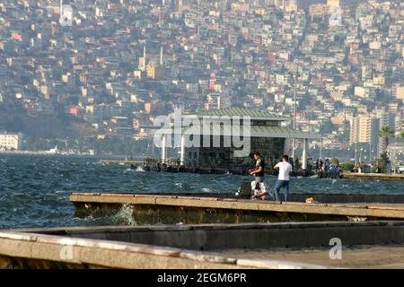 IZMIR, TÜRKEI - 26. JUNI: Jugendliche fischen an der Küste von Alsancak in Izmir, 26. Juni 2005 in Izmir, Türkei. Izmir ist die drittbevölkerungsreichste Stadt in der Türkei. Diese Küste ist bekannt als Kordon. Stockfoto