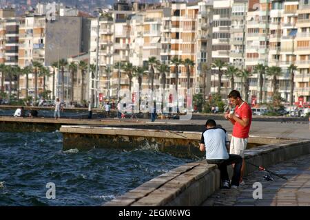 IZMIR, TÜRKEI - 26. JUNI: Jugendliche fischen an der Küste von Alsancak in Izmir, 26. Juni 2005 in Izmir, Türkei. Izmir ist die drittbevölkerungsreichste Stadt in der Türkei. Diese Küste ist bekannt als Kordon. Stockfoto