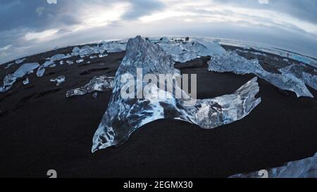 Eisfelsen am schwarzen Sandstrand am Diamond Beach South Ostisland Stockfoto