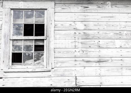 Weißes Fenster an der alten Scheunenwand Stockfoto