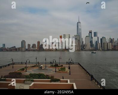 New York von New Jersey aus gesehen Sonnenuhr im Vordergrund eine Möwe und eine Bootsfahrt durch, Tageszeit Stockfoto