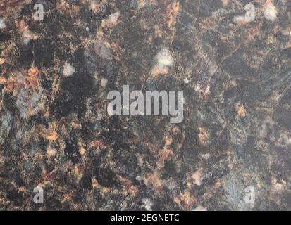 Schwarzer Marmor, polierte Oberfläche aus Naturstein mit orangen Adern und mit Grau durchsetzt. Hintergrund, Muster, Textur. Stockfoto