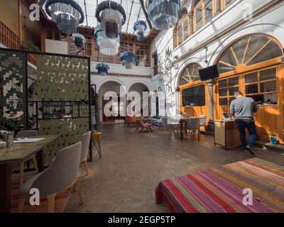 Peru, Cusco - 18. September 2019 - Selina Plaza de Armas Hostel Restaurant Bereich, Zeichen an der Wand blaue Lampen hängen von der Decke Stockfoto