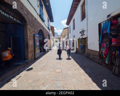 Peru, Cusco - 28. September 2019 - Menschen, die die Straße entlang mit Kunsthandwerk und Tour-Läden Stockfoto