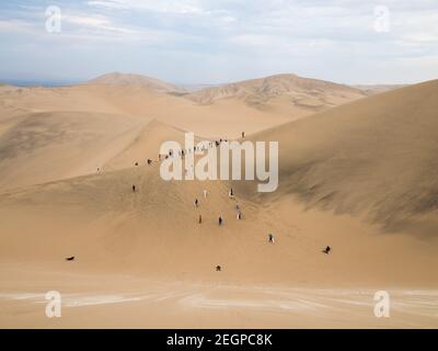 Viele Touristen stehen auf den Sanddünen in der Ica Wüste In Peru Stockfoto