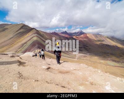 Peru, Vinicunca - 27. September 2019 - der Mensch fotografiert mit dem Handy die Landschaft am Regenbogenberg Stockfoto