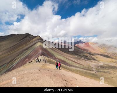 Peru, Vinicunca - 27. September 2019 - Trekker klettern vom Berg der sieben Farben hinunter Stockfoto