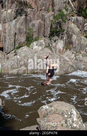 Ein Mann taucht von Felsen in den unteren Teil des Cataract Gorge Reserve in Launceston in Tasmanien. Stockfoto