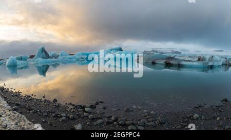 Blaue Eisberge an der Jokulsarlon Gletscherlagune in island spiegeln sich die Farben des Sonnenuntergangs auf dem Wasser Stockfoto