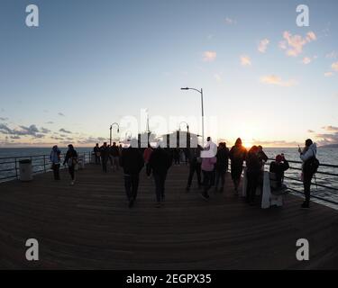 Santa Monica, USA - 24. Juli 2019 - Sonnenuntergang vom Santa Monica Pier aus betrachtet, strahlen die Sonnenstrahlen über der Menge Stockfoto