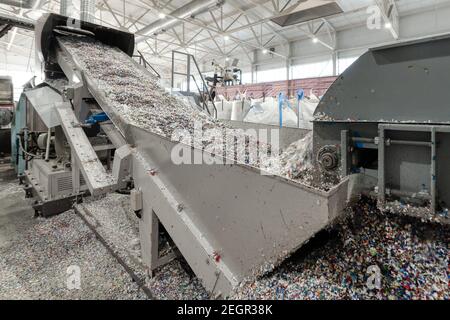 Kunststoff-Recycling-Anlage. Förderer mit geschreddertem Kunststoff Stockfoto