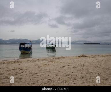 Zwei Boote schließen zwei der Strand von San Blas Panama, Bergkette und Insel im Hintergrund, an einem bewölkten Tag Stockfoto