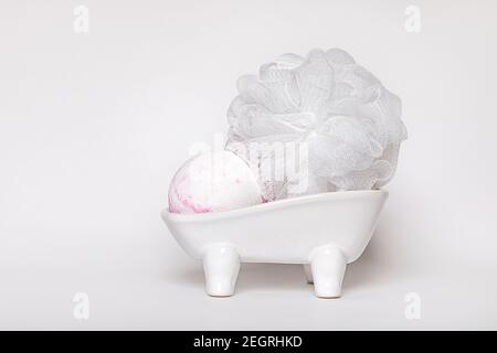 Weiße Keramik-Tablett mit Seifenschale, Waschlappen und Bomb duftenden Badeschaum. Konzept von Waschen, Sauberkeit, Hygiene. Nahaufnahme. Stockfoto