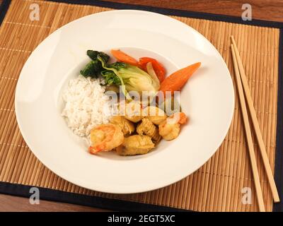 Red Thai Curry mit Huhn und Garnelen mit gebratenem Gemüse und Reis, gesundes Lebensmittelkonzept Stockfoto