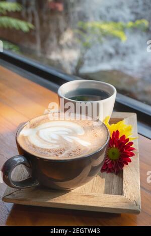 Latte Kaffee Kunstbecher im Garten, Stock Foto Stockfoto
