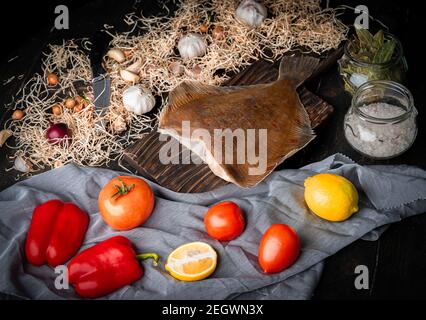 Rohe kopflose Flunder mit Zitronen und Gemüse. Stockfoto