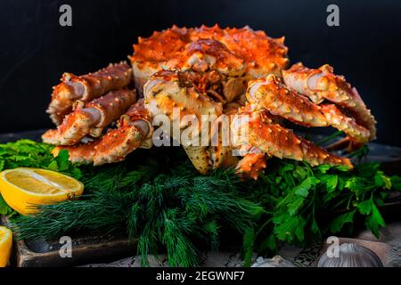 Leckere kamtschatka Krabbe mit Zitronenscheiben auf Holzbrett Stockfoto