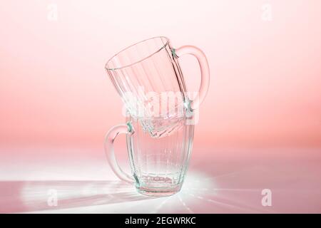 Zwei leere Biergläser auf dem Tisch in rosa Licht Stockfoto