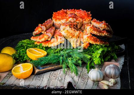 Leckere kamtschatka Krabbe mit Zitronenscheiben auf Holzbrett Stockfoto