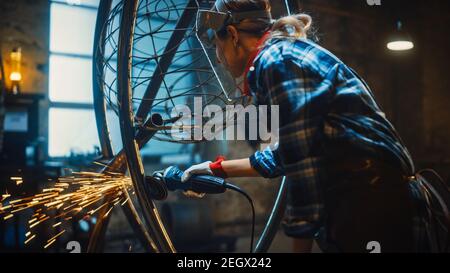 Talented Emerging Female Artist verwendet einen Disc Grinder, um eine abstrakte, brutale Metallskulptur zu machen, die den gegenwärtigen Moment widerspiegelt. Wunderschöner Tomboy Stockfoto