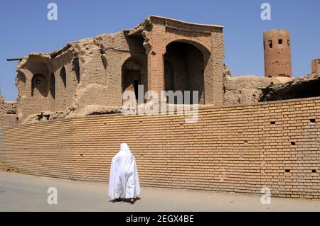 Traditionelle Iranische Häuser. Eine iranische Frau in einem weißen Kleid. Eine mittelalterliche Stadt im Iran. Barzaneh, Nord-Khorasan, Iran. Stockfoto