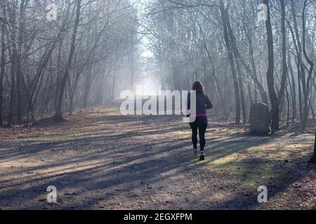 Lonate Pozzolo, Varese-Italien - Dezember 13.2020 Läufer laufen im Winter auf Waldwegen. Stockfoto