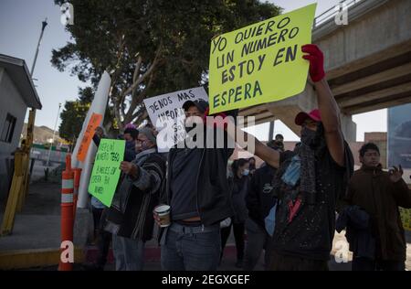 18. Februar 2021, Mexiko, Tijuana: Humanitäre Asylsuchende in den USA rufen Slogans gegen mexikanische und US-Behörden auf, die am Grenzübergang ankamen, um ein Koordinationstreffen abzuhalten. Zentralamerikanische und mexikanische Migranten, die Flüchtlinge im Flüchtlingsheim Agape sind, demonstrierten vor dem Haupteingang des Grenzübergangs El Chaparral an der Grenze zwischen Tijuana, Mexiko, Und San Diego, Kalifornien, mit dem Ziel, die US-Behörden aufzufordern, die Grenze zu öffnen und den Prozess der Gewährung von politischem Asyl für Flüchtlinge neu zu starten. Nach der Richtungsänderung der Migrationspolitik wird die U Stockfoto