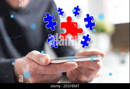 Hände des Mannes hält ein Smartphone mit Teamwork-Konzept Stockfoto