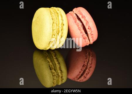 Ein ganzer aromatischer süßer köstlicher Macaron auf schwarzem Hintergrund. Stockfoto