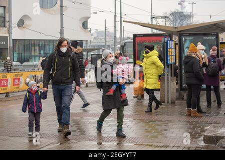 Brünn, Tschechische Republik. 02-17-2021. Mutter Vater und zwei Kinder tragen Masken sind auf Halvni Nadrazi Hauptbahn und Bahnhof in der Stadt c zu Fuß Stockfoto