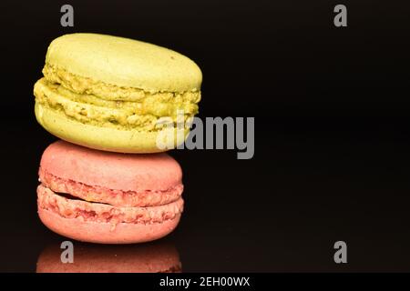 Ein ganzer aromatischer süßer köstlicher Macaron auf schwarzem Hintergrund. Stockfoto