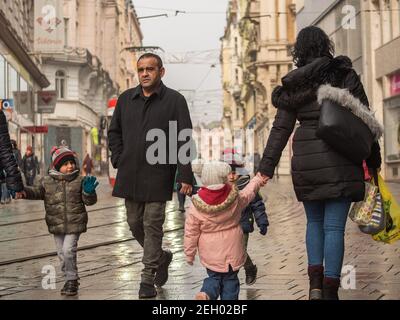 Brünn, Tschechische Republik. 02-17-2021. Mutter Vater und Kinder zu Fuß auf Masarykova Straße in der Stadt Brünn am kalten Wintertag. Stockfoto