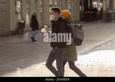 Brünn, Tschechische Republik. 02-17-2021. Junges Paar mit Gesichtsmaske, um Corona-Virus auf dem Platz der Freiheit in der Stadt Brünn im Winter zu schützen. Stockfoto