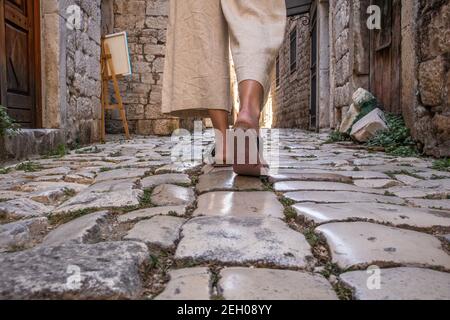 Detail Aufnahme der weiblichen Beine tragen bequeme Reise Sandalen Spaziergang auf alten mittelalterlichen Kopfsteinpflaster Straße dring Sightseeing City Tour. Reisen, Tourismus Stockfoto