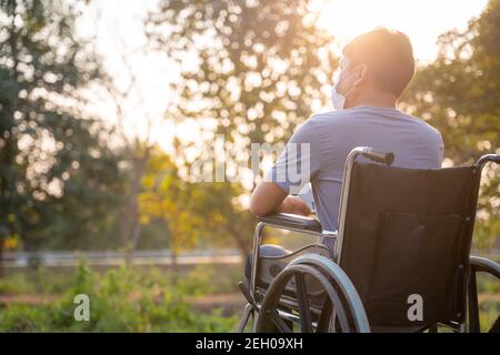 Behinderter Mann entspannen im Rollstuhl im Park. Stockfoto