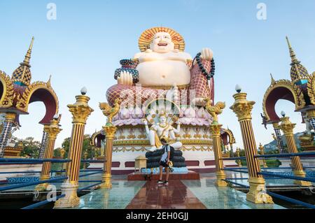 KOH SAMUI, THAILAND - 10. Januar 2020: Mann mit Kamera steht auf einer Brücke zu einer riesigen, farbenfrohen buddha-Statue am Wat Plai laem-Tempel auf koh samui Stockfoto