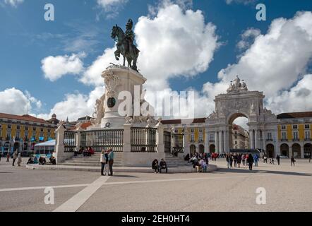 LISSABON, PORTUGAL - 13. APRIL 2016: Touristen erkunden Triumphbogen und König Jose I Bronzestatue auf dem ikonischen Commerce Square im Zentrum von Stockfoto