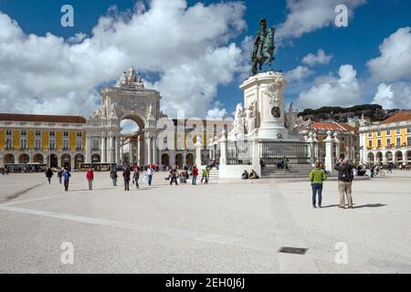 LISSABON, PORTUGAL - 13. APRIL 2016: Touristen erkunden Triumphbogen und König Jose I Bronzestatue auf dem ikonischen Commerce Square im Zentrum von Stockfoto