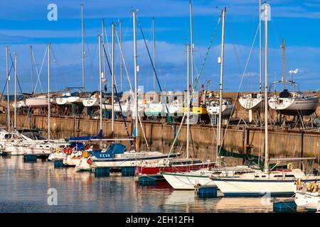 LOSSIEMOUTH HAFEN MORAY KÜSTE SCHOTTLAND BUNTE YACHTEN IN DER MARINA UND AN DER HAFENMAUER Stockfoto