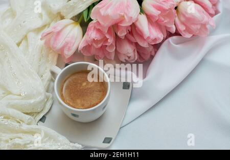 Aromatischer Morgenkaffee in einer weißen Keramikschale. Große schöne Bouquet von Frühlingsblumenblüten. Stockfoto
