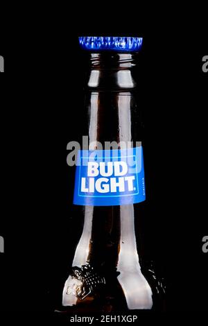 Sandhurst, Vereinigtes Königreich; Februar 16th 2021:- EINE Nahaufnahme einer offenen Flasche Bud Light mit einer Flaschenspitze auf der Lippe, isoliert auf einem schwarzen Hintergrund Stockfoto