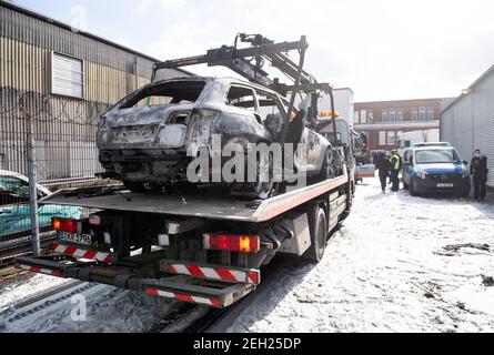 Berlin, Deutschland. Februar 2021, 19th. Ein ausgebrannter Audi wird von der Polizei in einem Supermarkt in Schöneberg abgeschleppt. Das Fahrzeug, das hinter dem Supermarkt abgestellt und in Brand gesetzt wurde, könnte das Fluchtfahrzeug der Täter des Raubes eines gepanzerten Autos auf dem Berliner Kurfürstendamm sein. Mehrere Täter sind geflohen, zwei Sicherheitsleute sollen verletzt worden sein. Quelle: Bernd von Jutrczenka/dpa/Alamy Live News Stockfoto