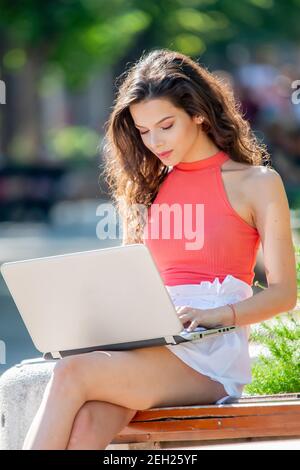 Junge Frau mit einem Laptop im Freien auf einem hellen Sommer Tag Stockfoto