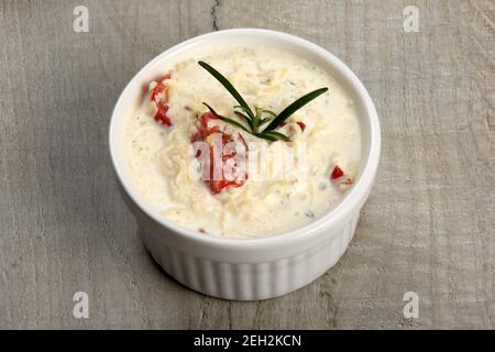 Ein Topf mit Auflauf - saure Sahne, Tomaten und Fisch oder andere Zutaten vor dem Backen. Gerichte mit ungebratenen Julienne Stockfoto