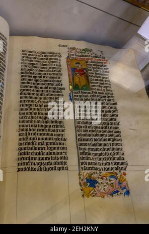 Nahaufnahme einer Seite der 600 Jahre alten vierteiligen Malmesbury-Bibel, ausgestellt in der Malmesbury Abbey, Malmesbury, Wiltshire, Großbritannien. Stockfoto